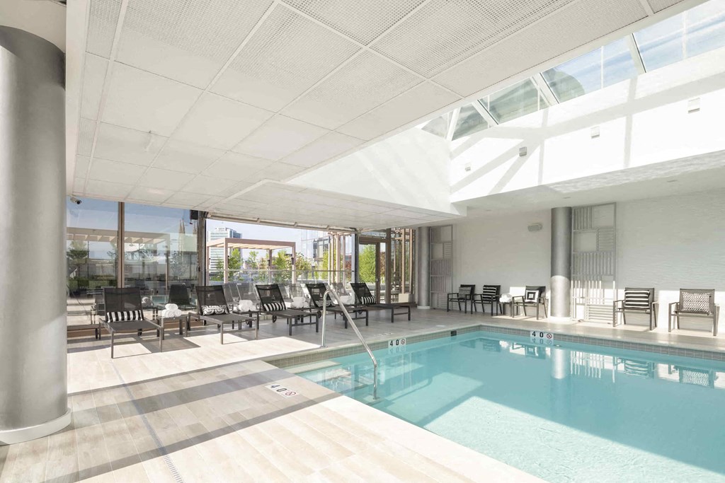 a swimming pool in a large room with tables and chairs