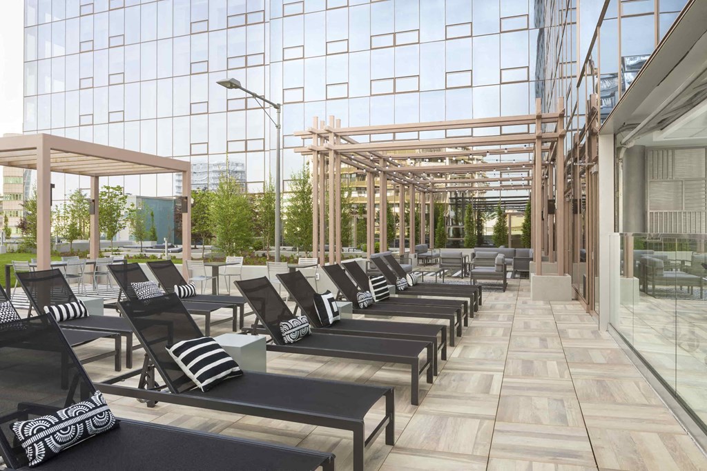 a lounge area with chairs and tables in front of a glass building