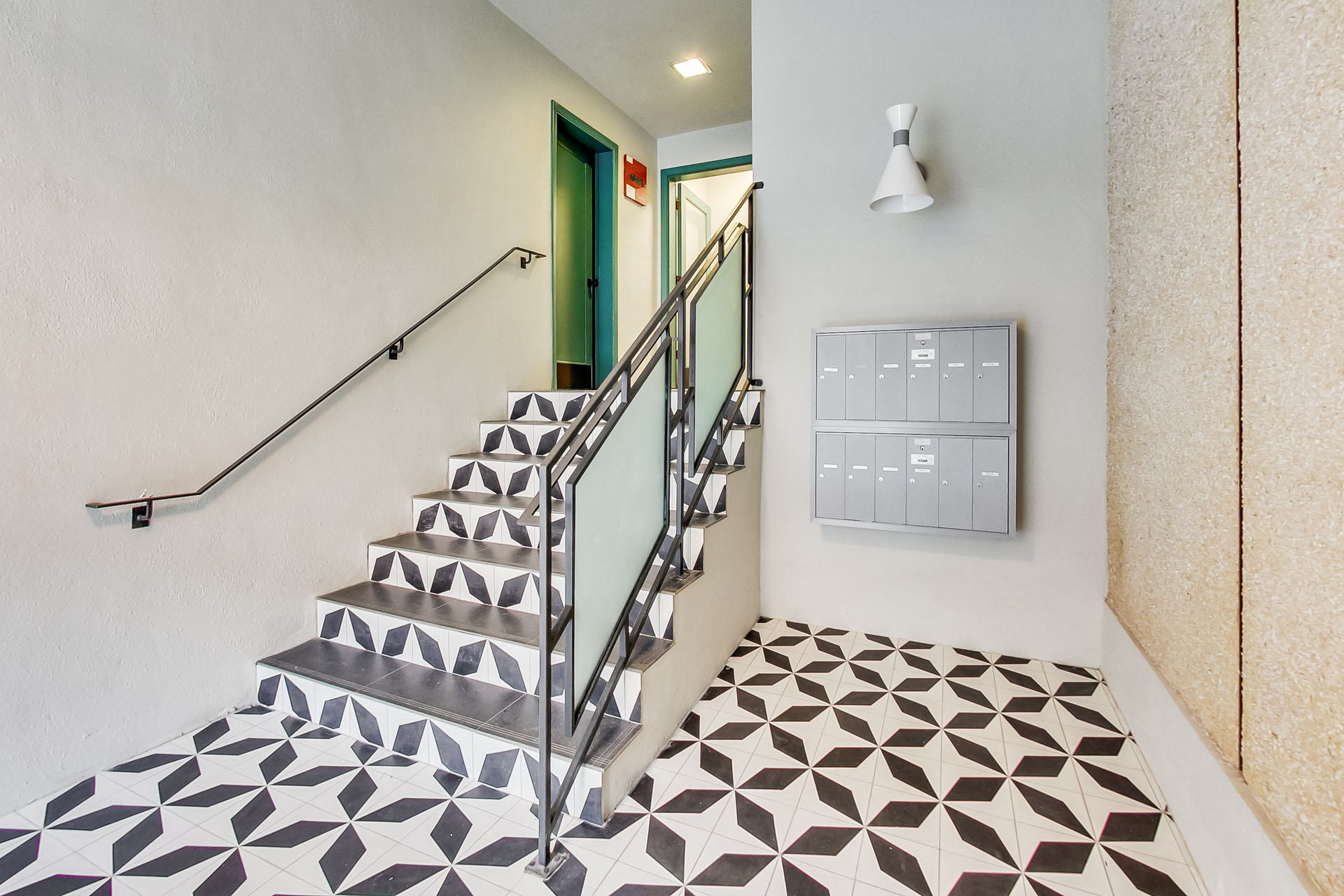 A staircase with a metal railing and a tiled floor.