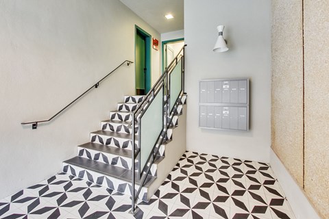 A staircase with a metal railing and a tiled floor.