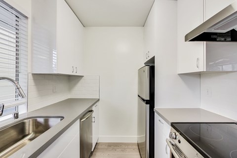 A kitchen with white cabinets and stainless steel appliances.