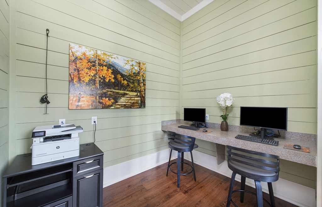 a home office with a desk with two computers and a printer