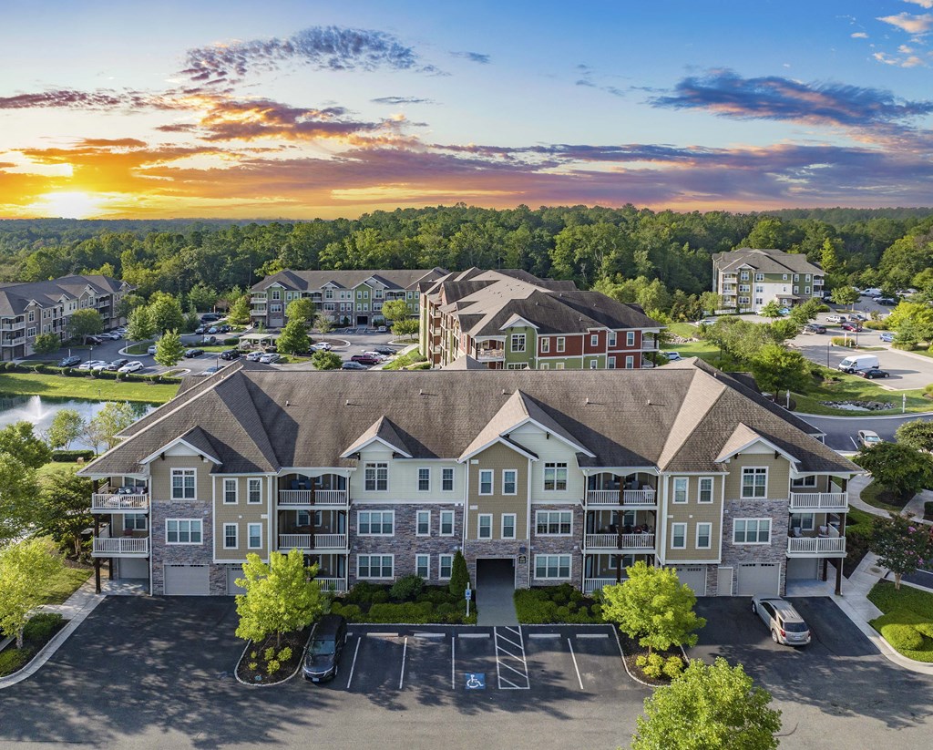 an aerial view of a large apartment building with a sunset in the background