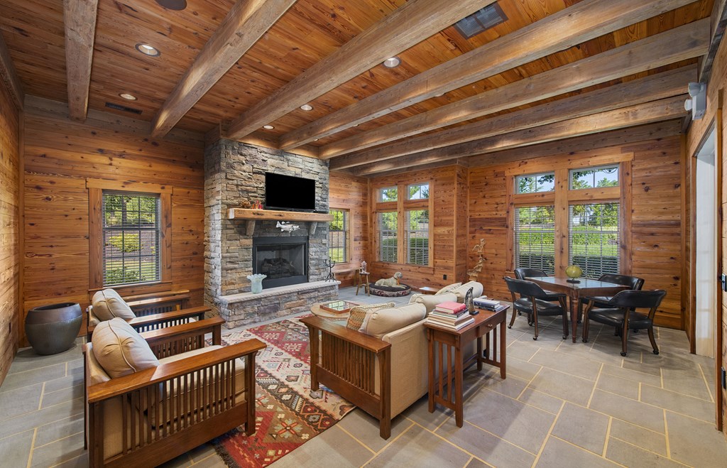 a large living room with a stone fireplace and wooden ceilings