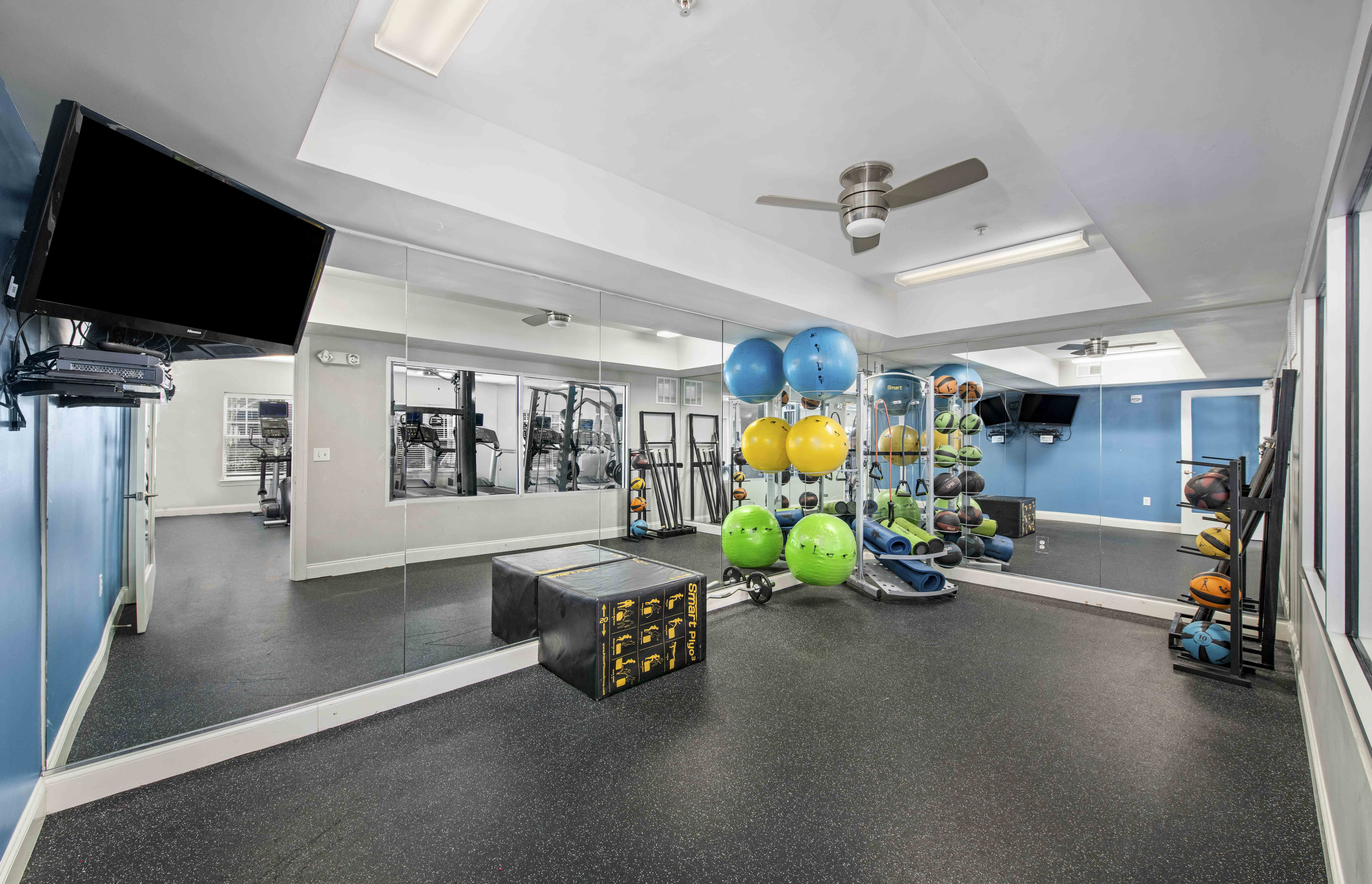 a workout room with weights and balloons and a tv