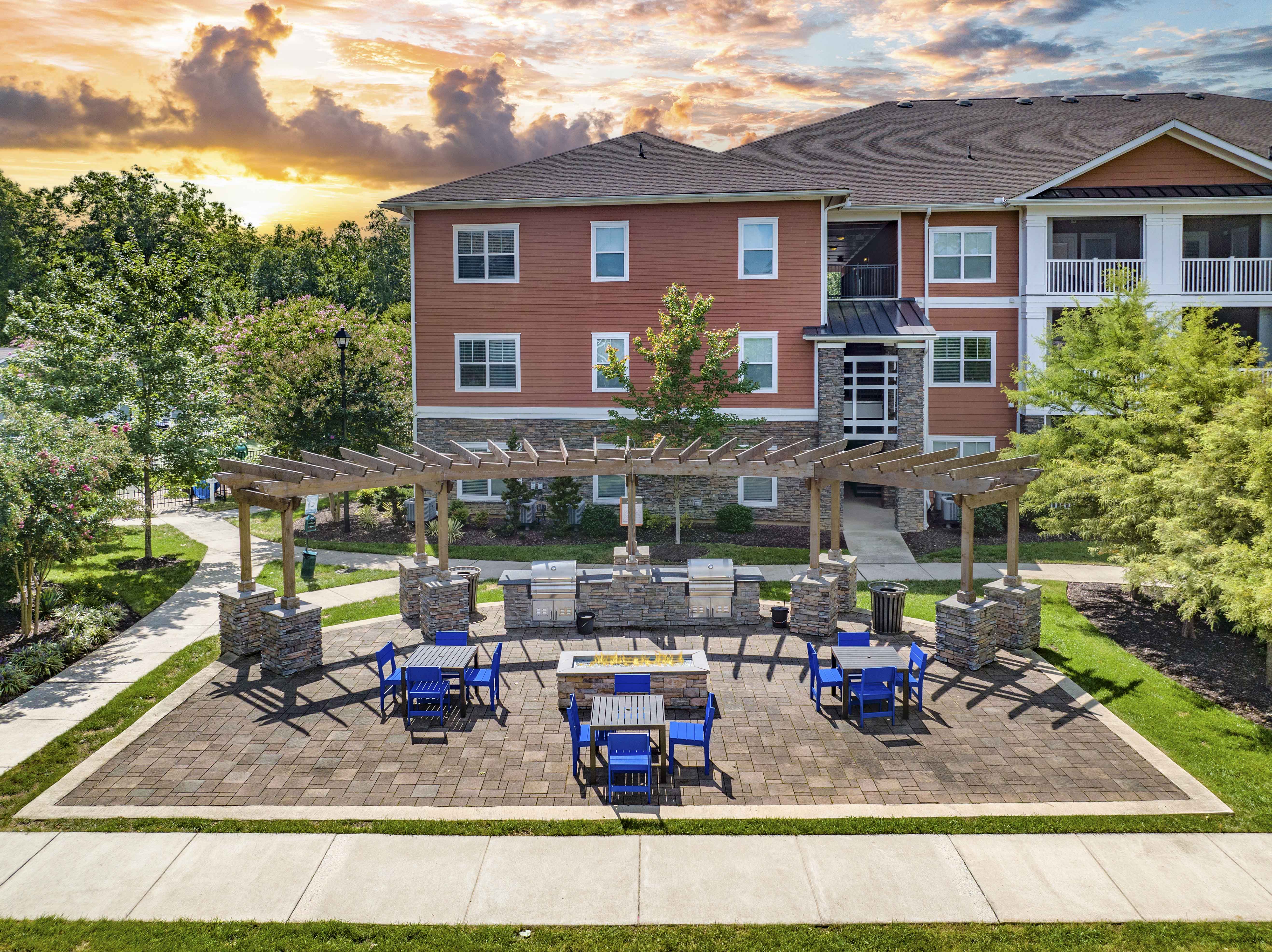 an outdoor patio with tables and chairs and a building in the background