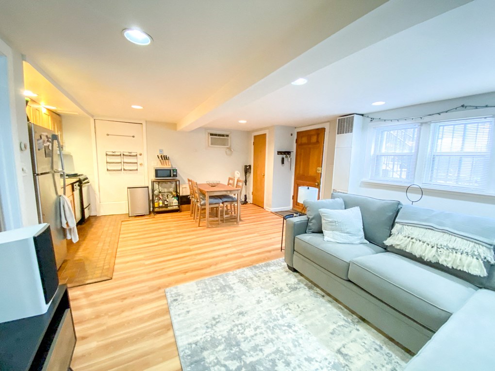 a living room and dining room with a couch and a rug
