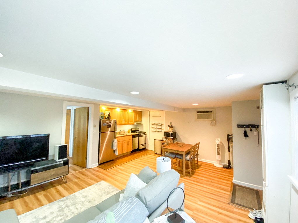 a living room with a couch and a tv and a kitchen