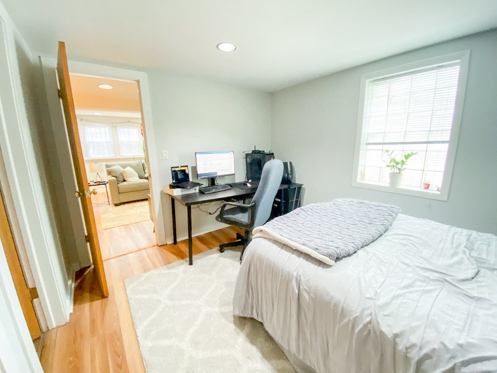 a bedroom with a bed and a desk with a computer