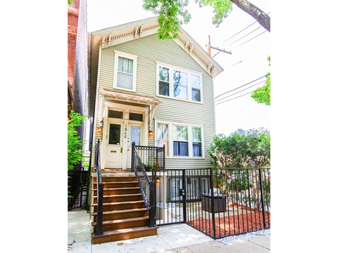 the front of a house with stairs and a fence