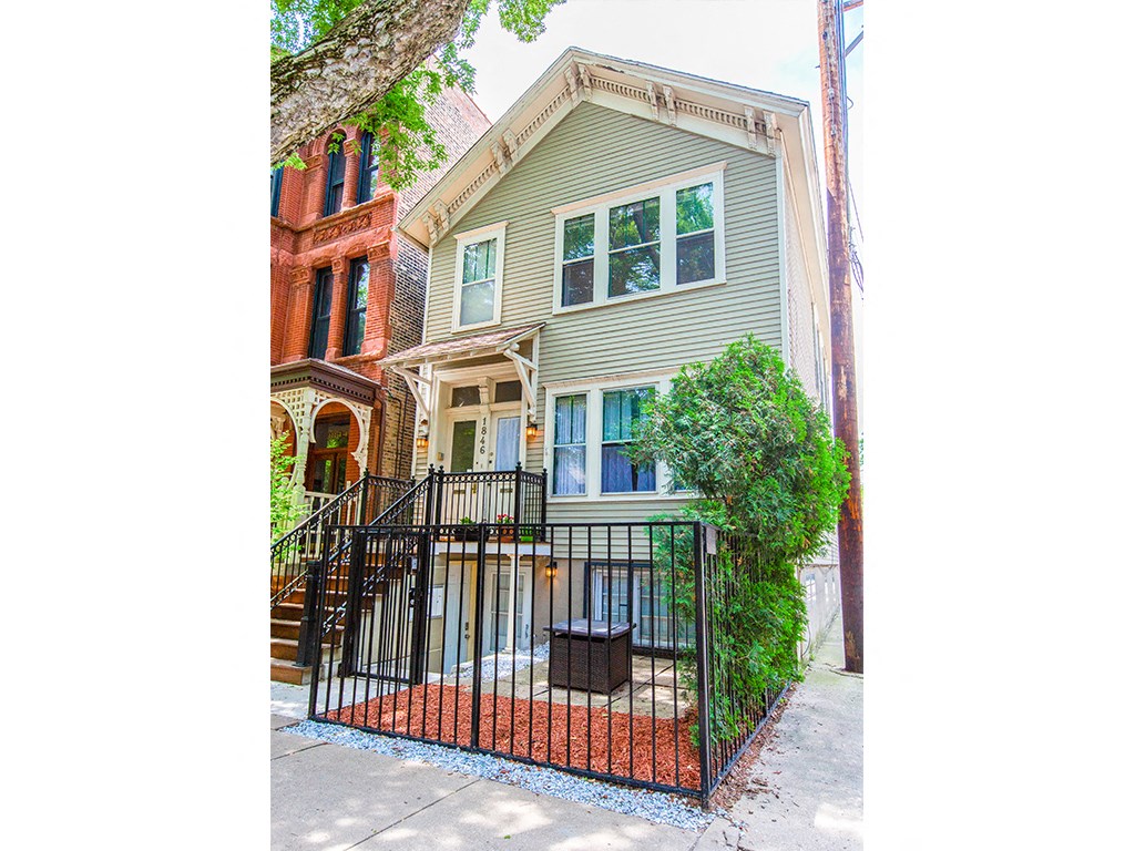 the front of a house with a yard and a gate