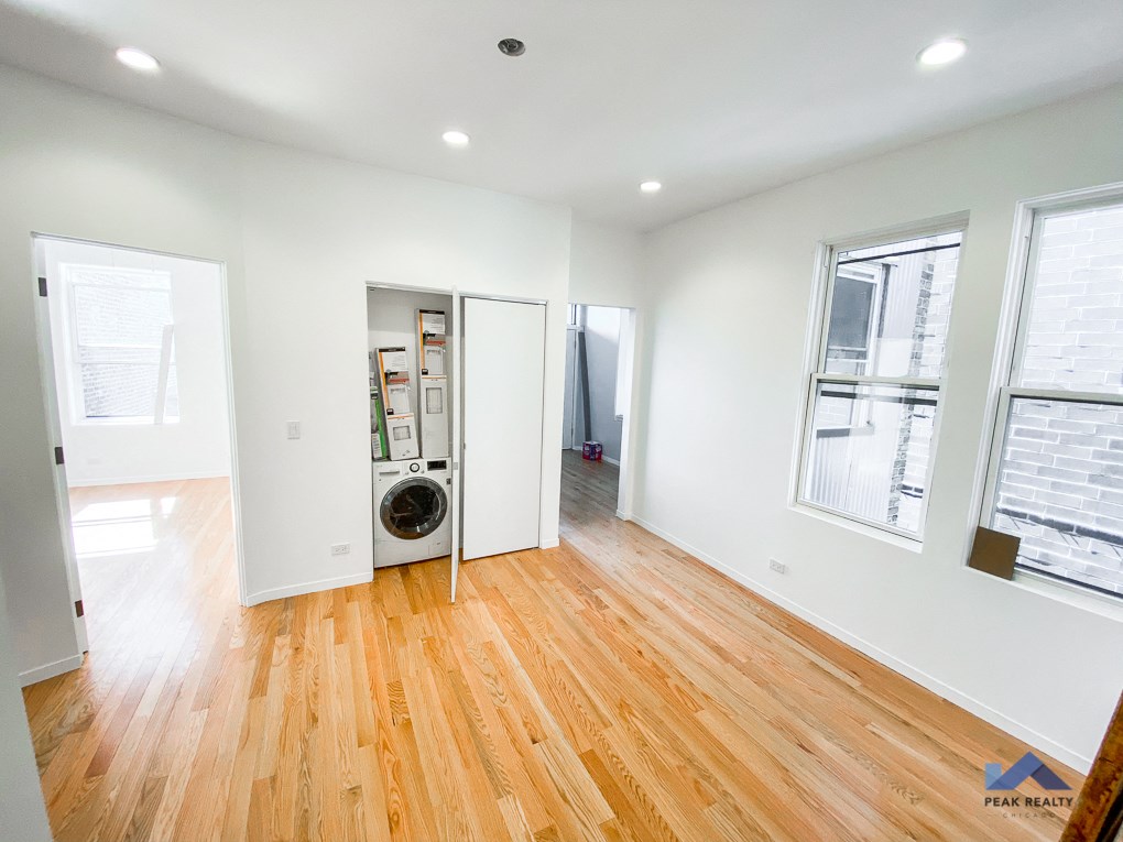 a living room with a wood floor and a washer and dryer in it
