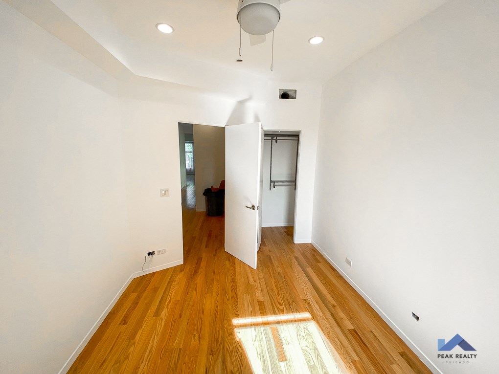 a renovated living room with white walls and wood floors