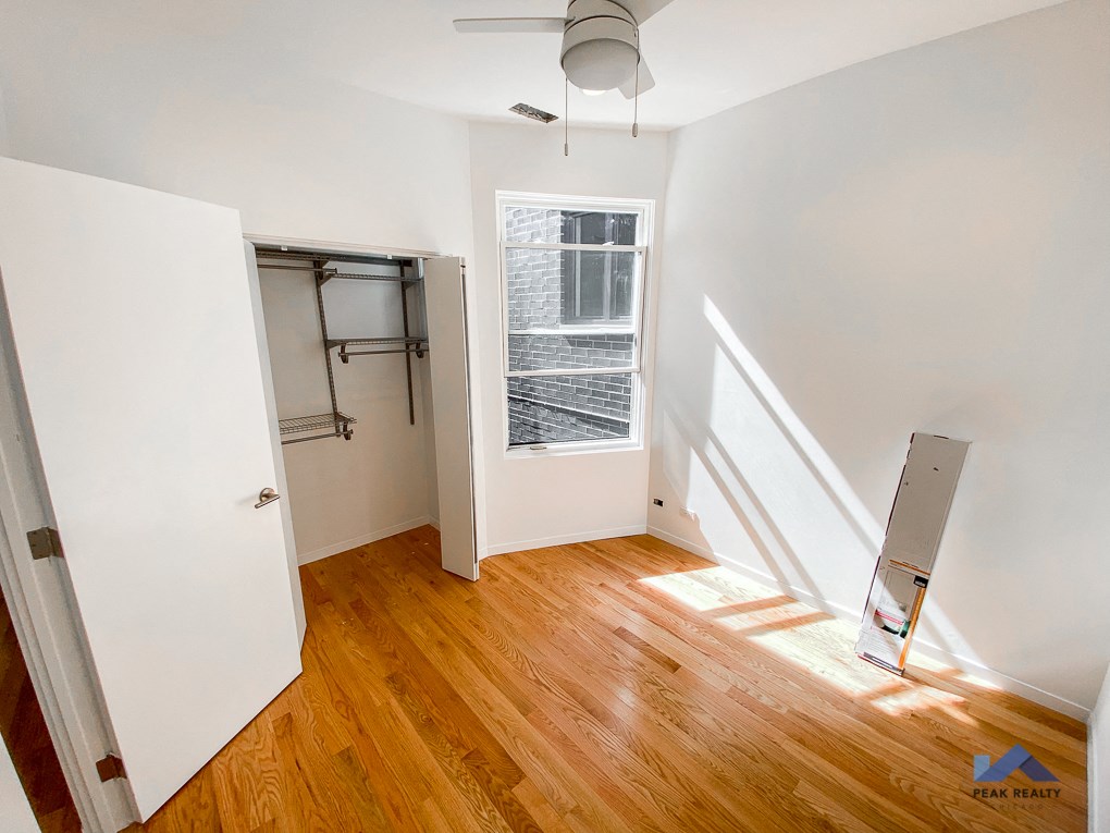 an empty room with a window and a closet