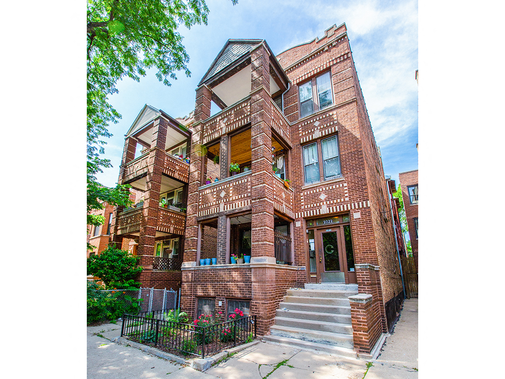 the exterior of a building with a red brick facade and stairs
