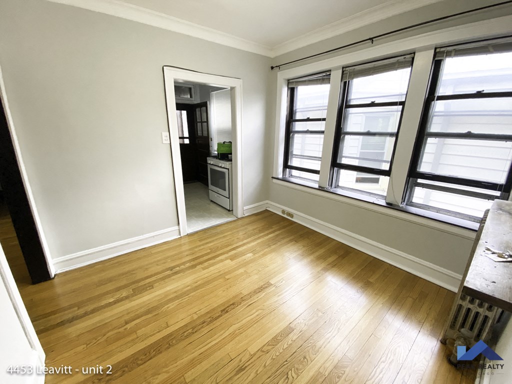 an empty living room with wood floors and windows