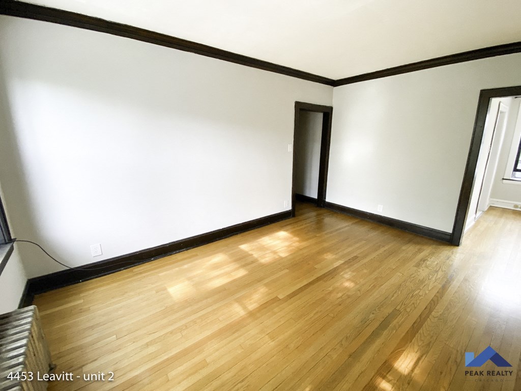 an empty living room with white walls and wooden floors