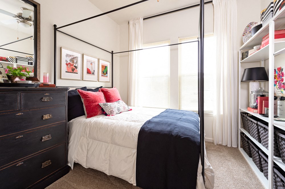a bedroom with a bed and a dresser and a window