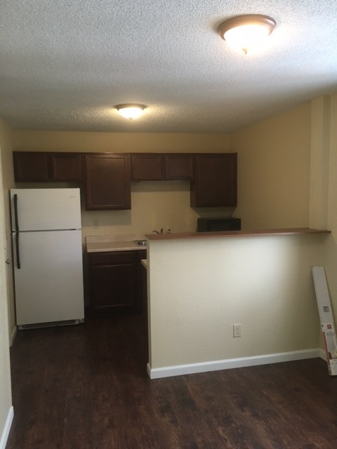 an empty kitchen with a refrigerator and a sink