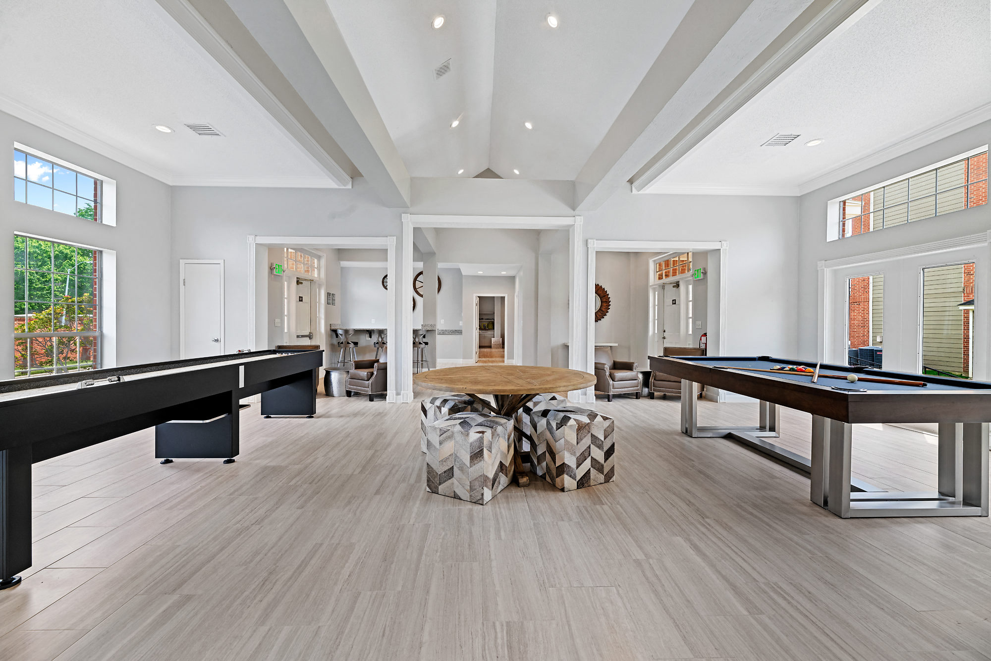 a game room with two pool tables and a dining table