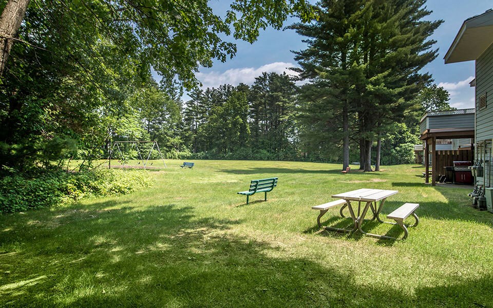 a backyard with a picnic table and a bench