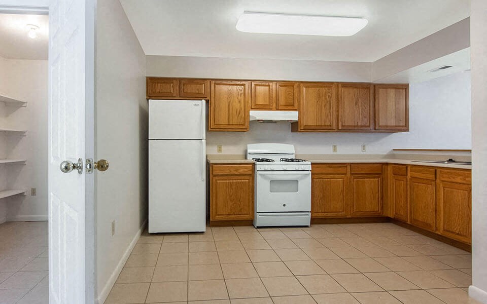 a kitchen with white appliances and wooden cabinets