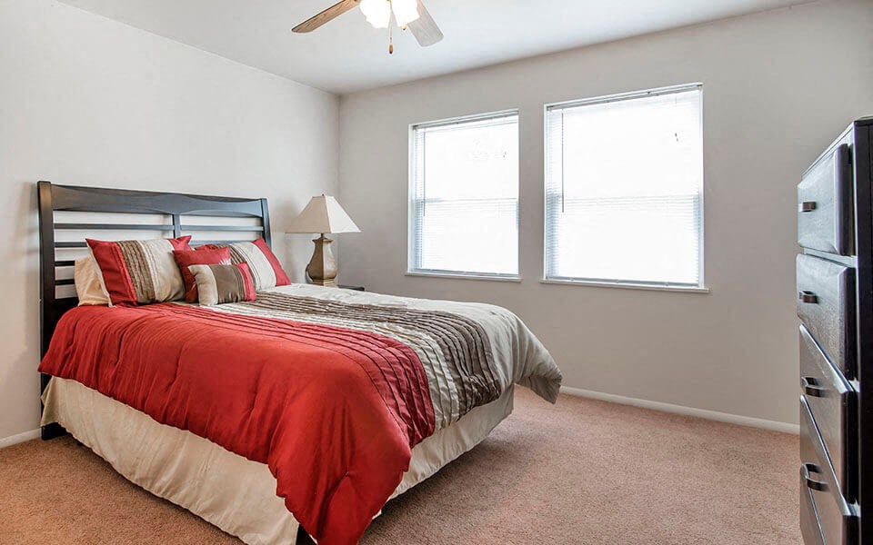 a bedroom with a bed and two windows