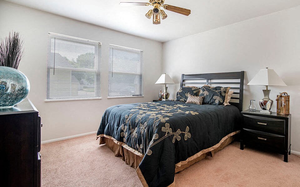 a bedroom with a bed and a ceiling fan