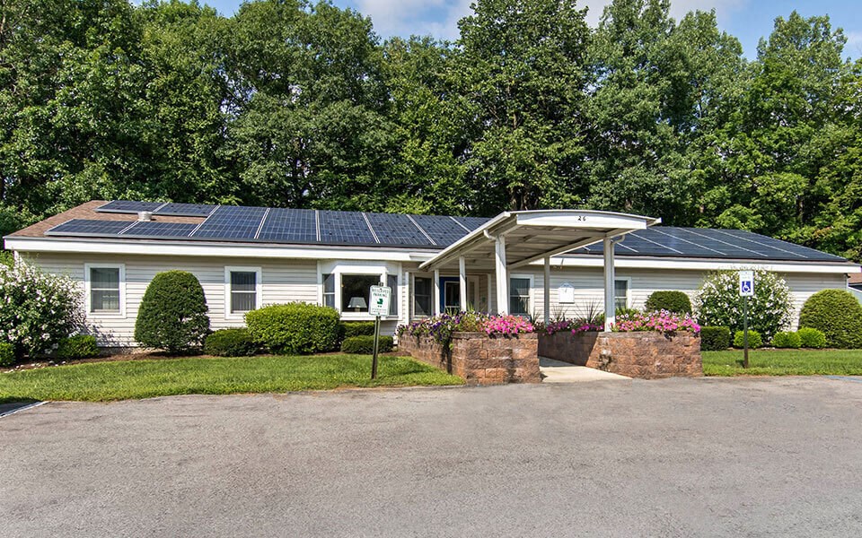 a white house with solar panels on the roof