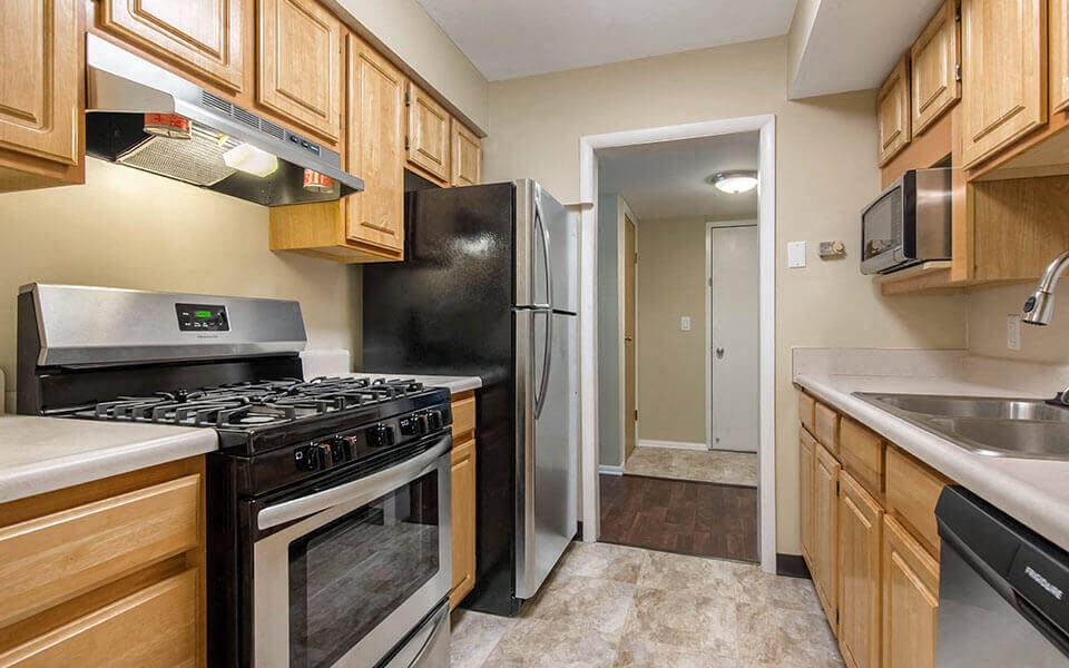 a kitchen with stainless steel appliances and wooden cabinets