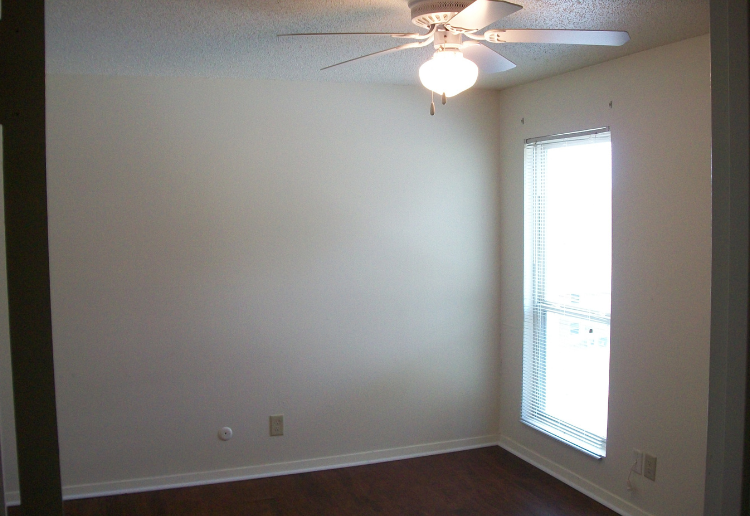 a bedroom with a ceiling fan and a window