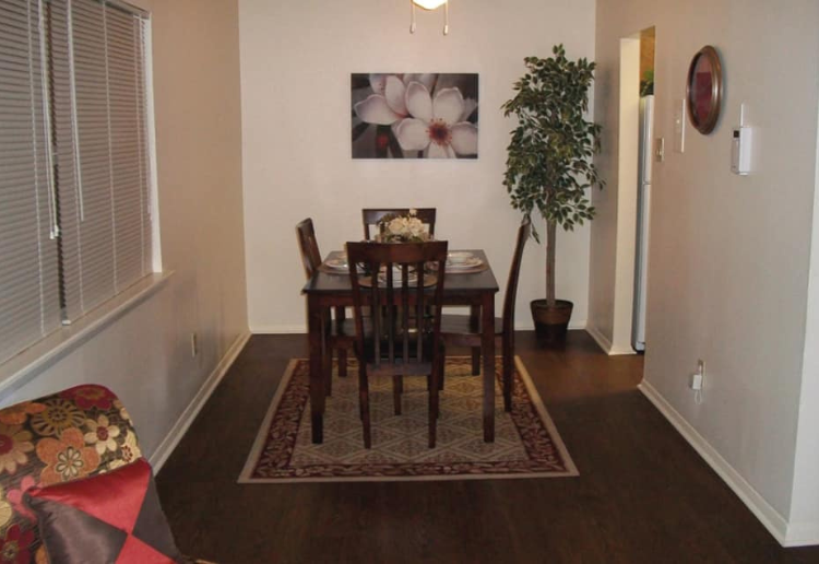 a dining room with a table and a potted plant