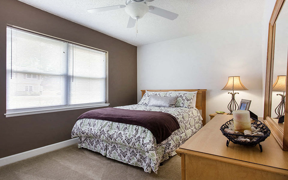 a bedroom with a bed and a ceiling fan