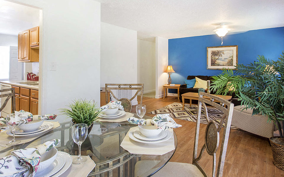 a living room and dining room with a glass table
