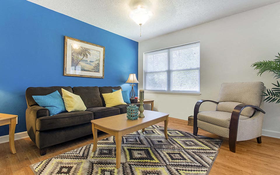 a living room with a couch and a chair and a table