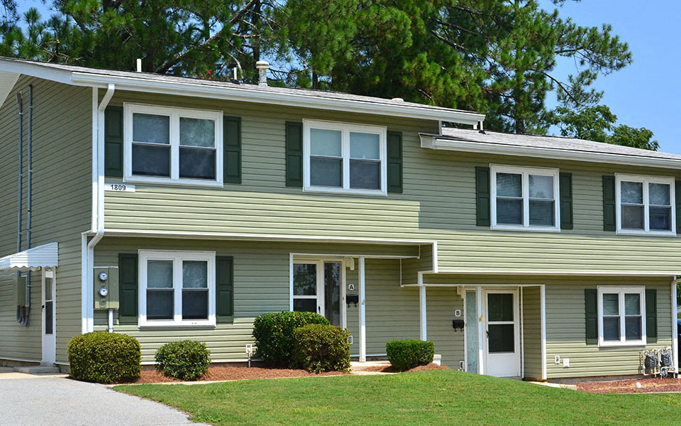 a green house with a lawn in front of it