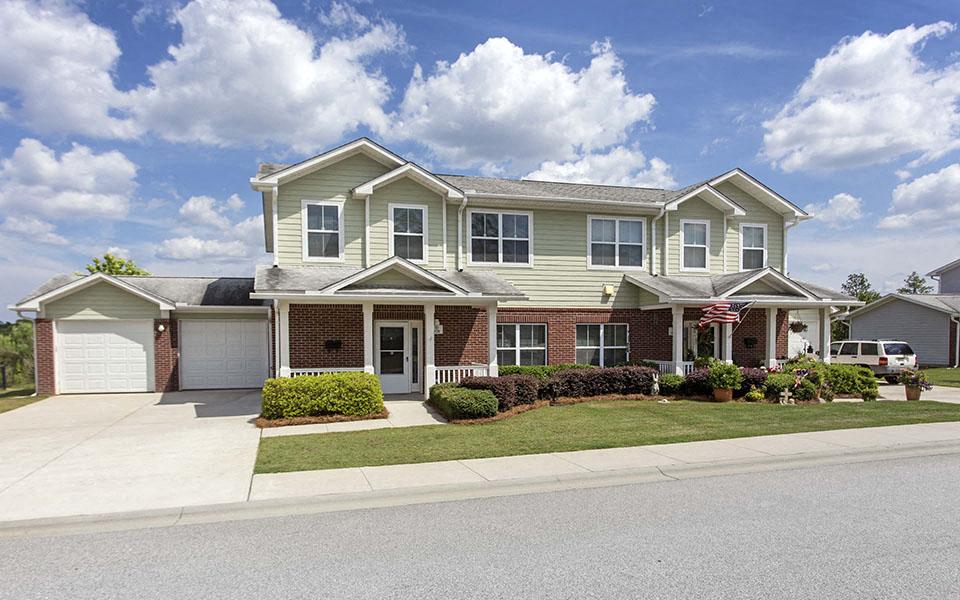 a house with a driveway and lawn in front of it