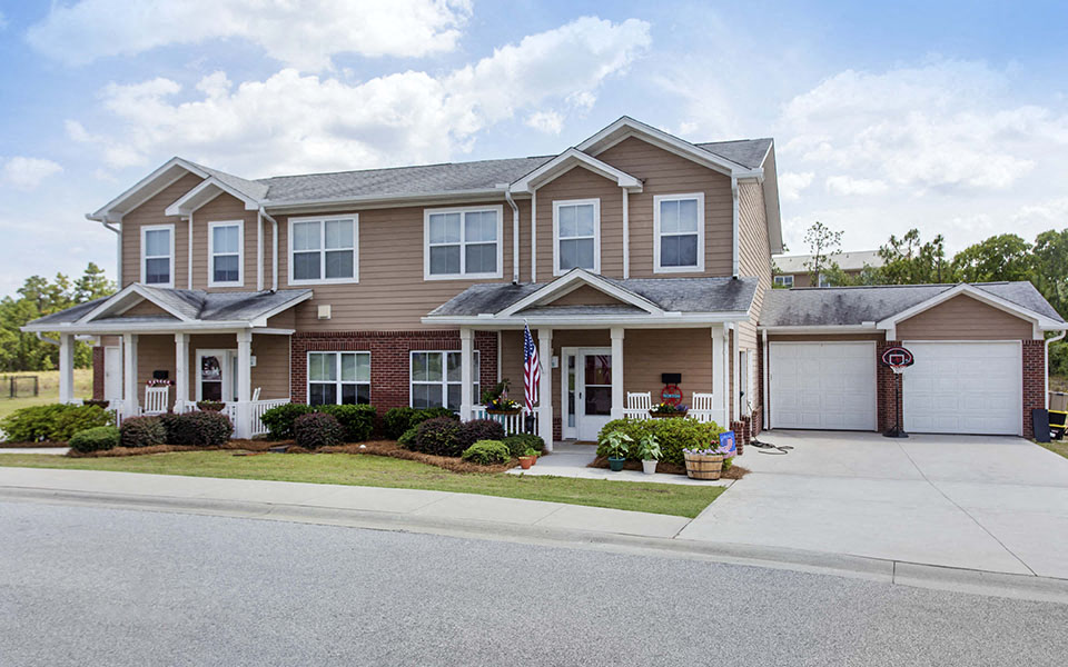 a house with a flag on the side of a driveway