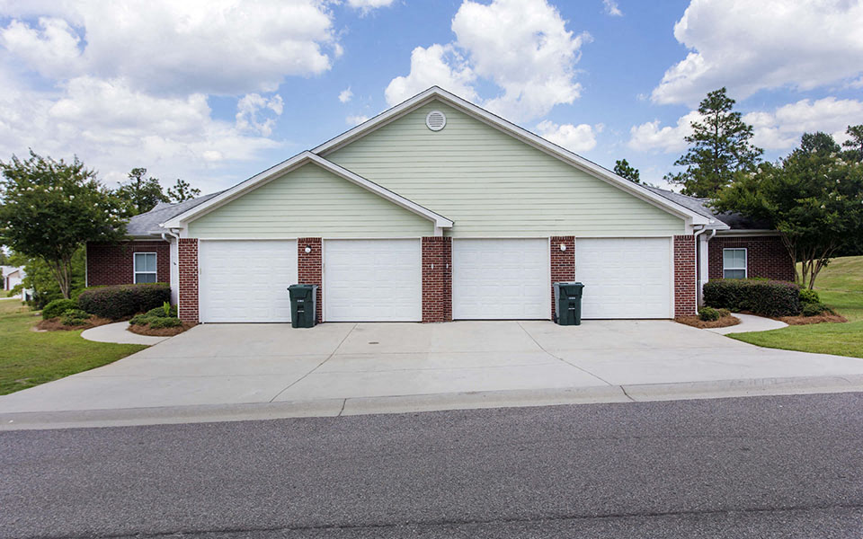the front of a white house with a driveway