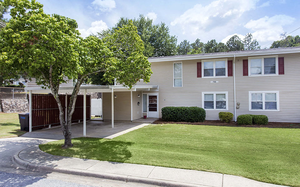 a house with a lawn and a tree in front of it