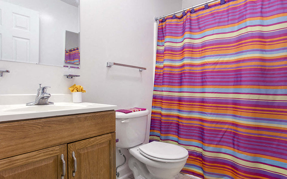 a bathroom with a shower and a toilet and a sink