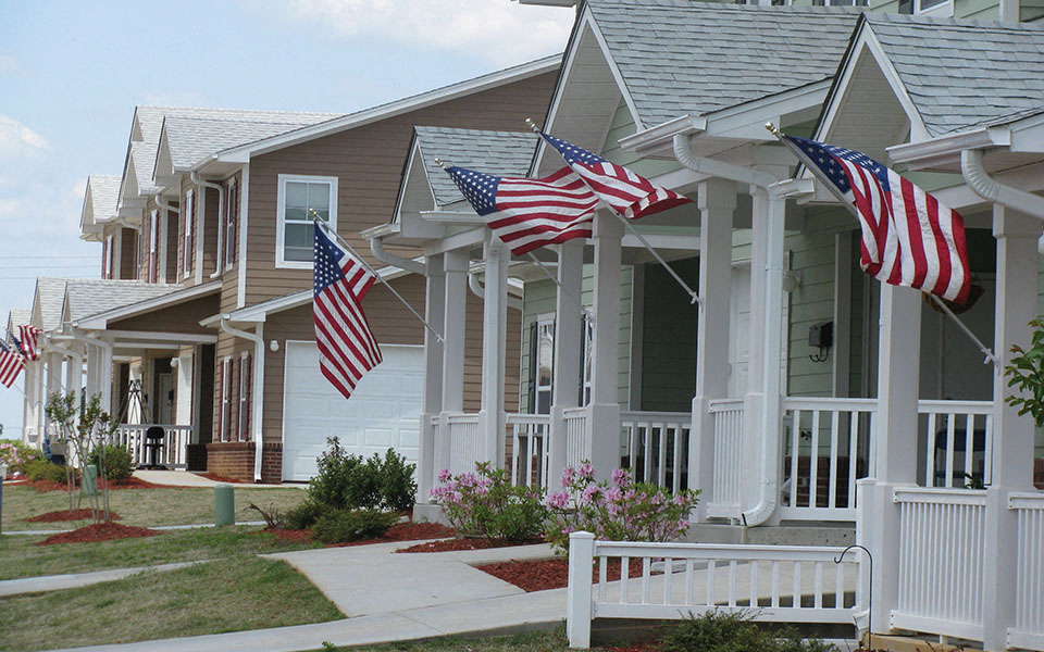 a row flags flying in front of houses