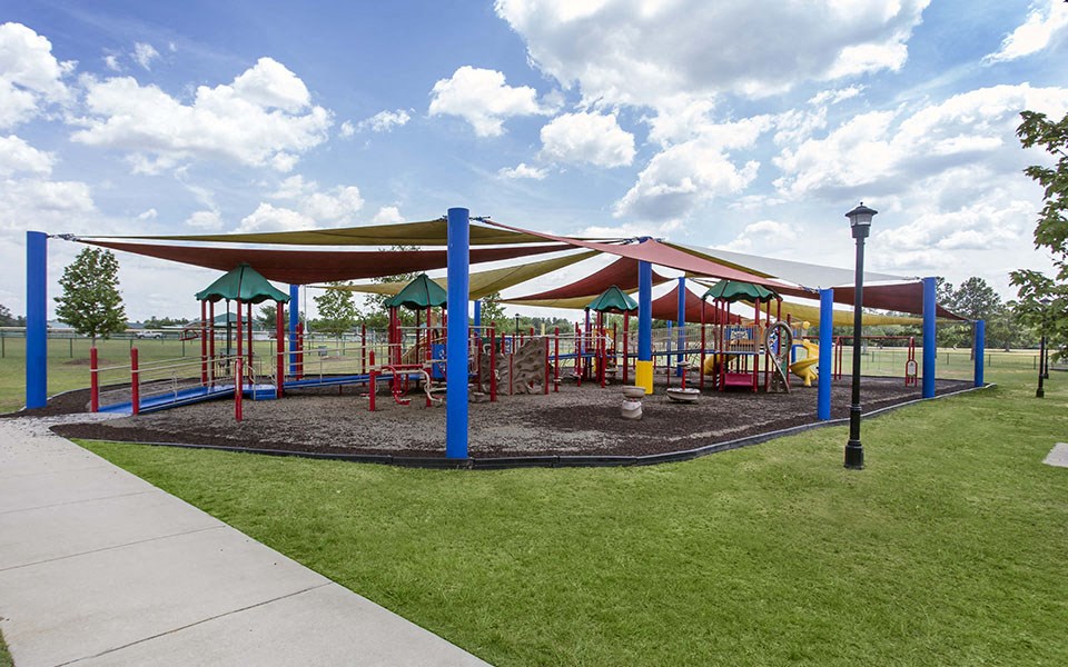 a playground with a colorful swing set and pavilion