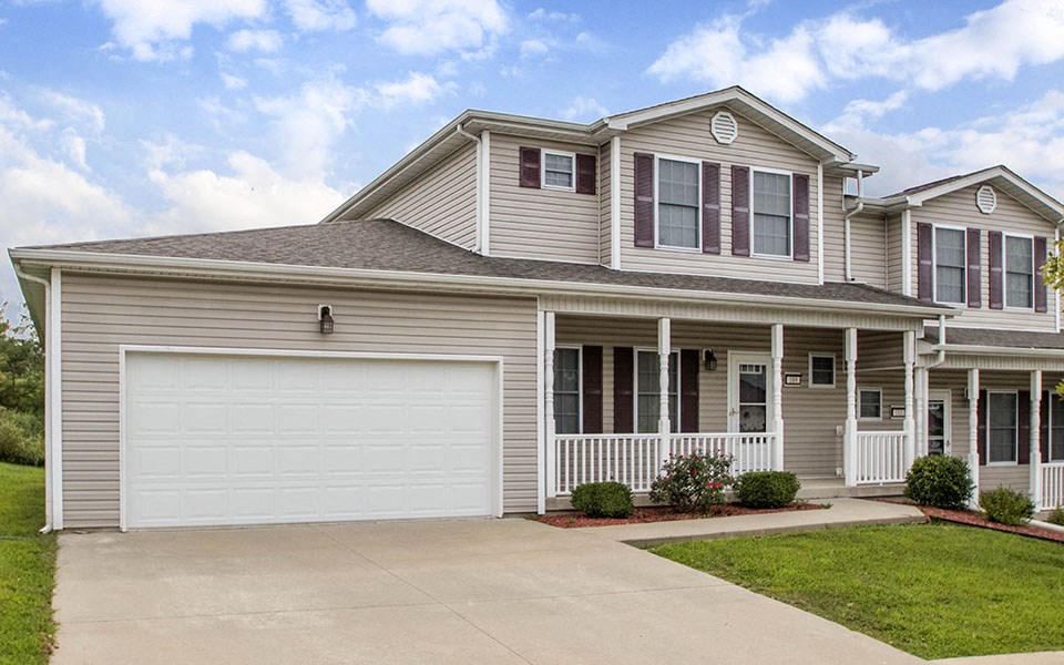 a beige house with a white garage door