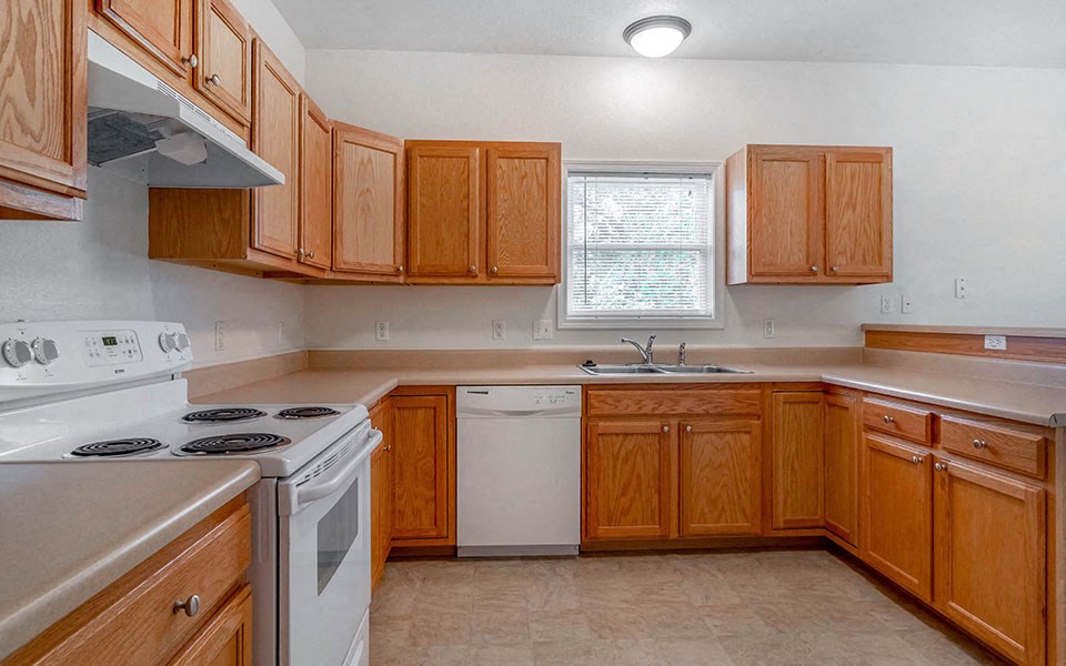 a kitchen with wooden cabinets and a stove and a sink