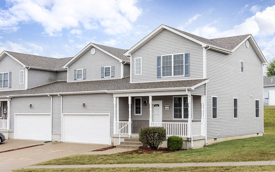 a white house with two stories and a porch