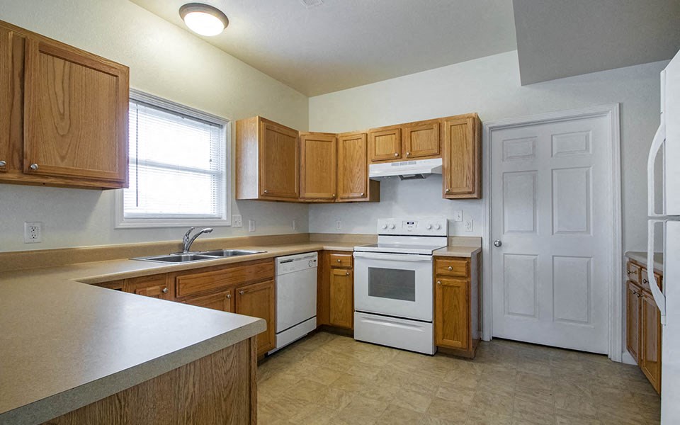 a kitchen with wooden cabinets and white appliances
