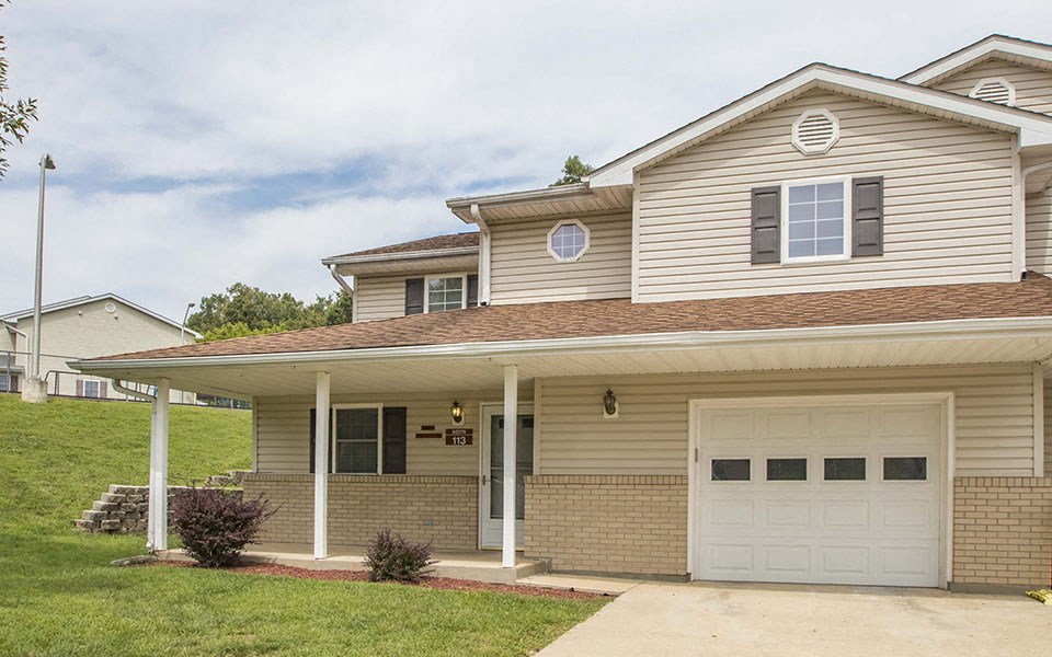 a tan house with a white garage door