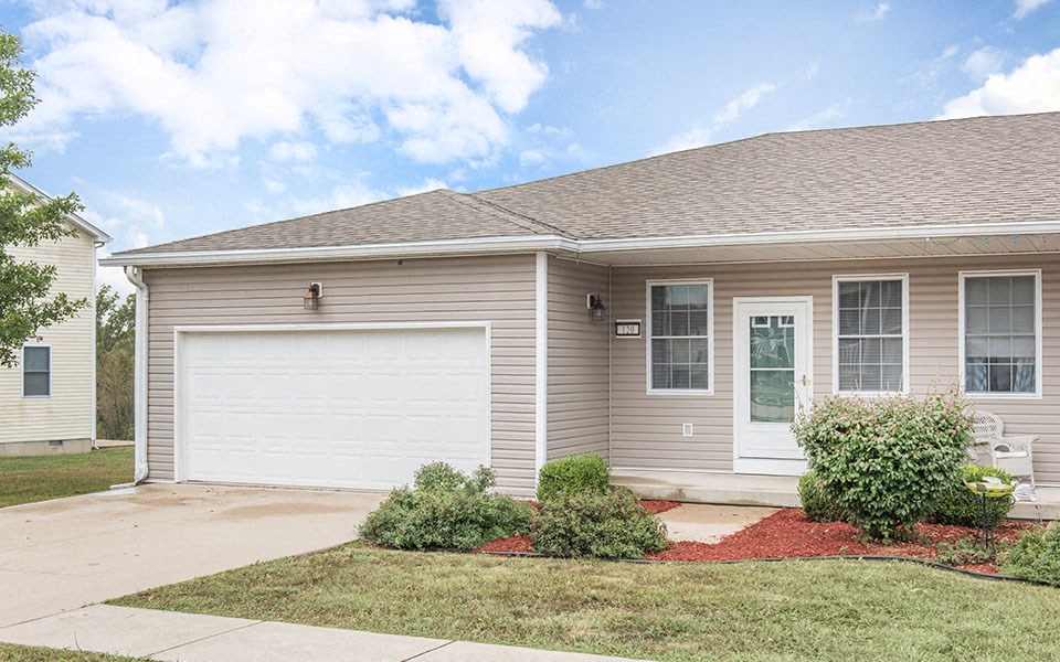 a tan house with a white garage door