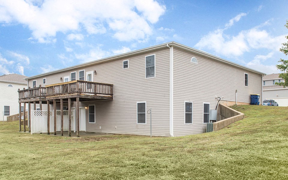 the back of a house with a deck on a hill